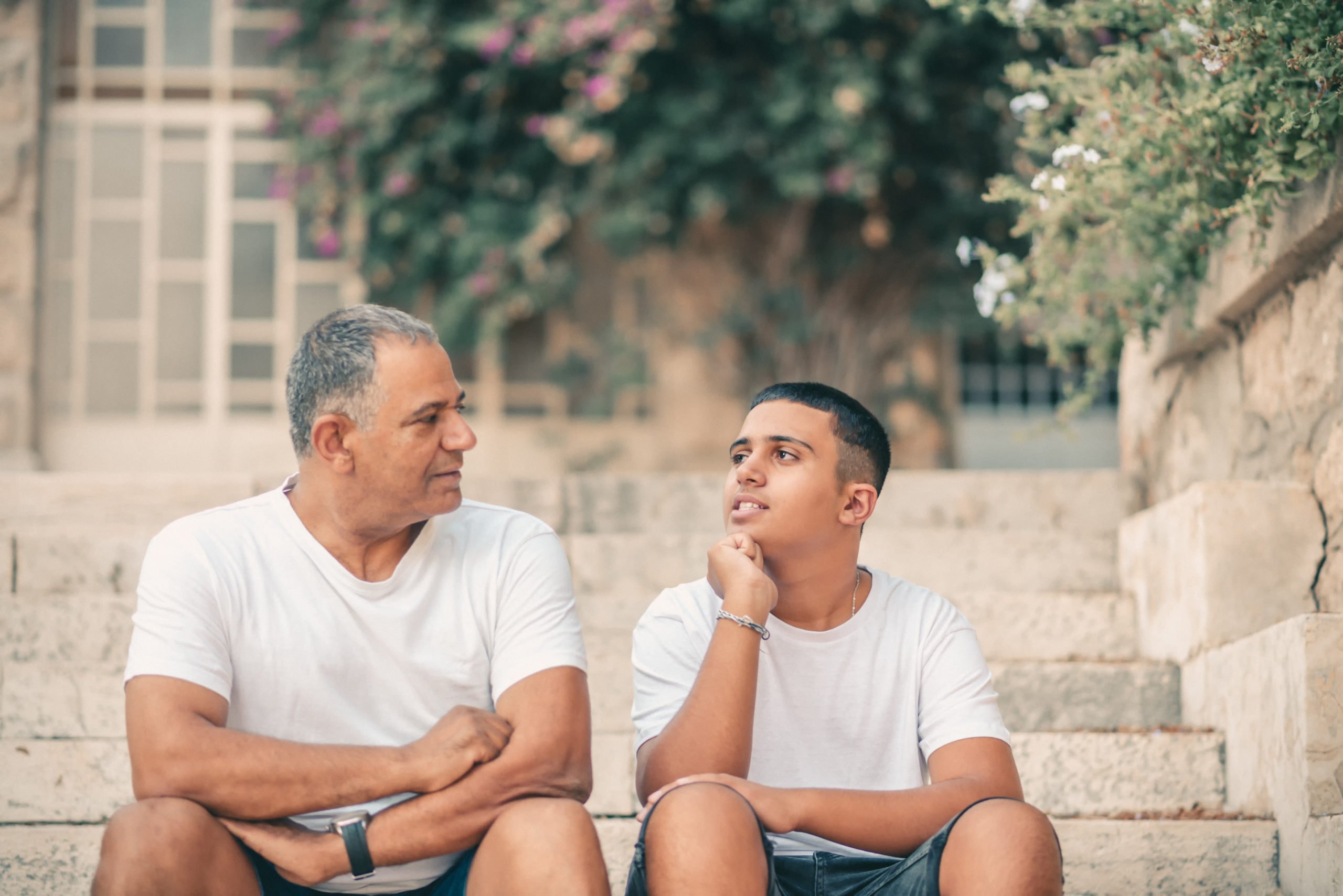 A father talking to his son while sitting on stone steps