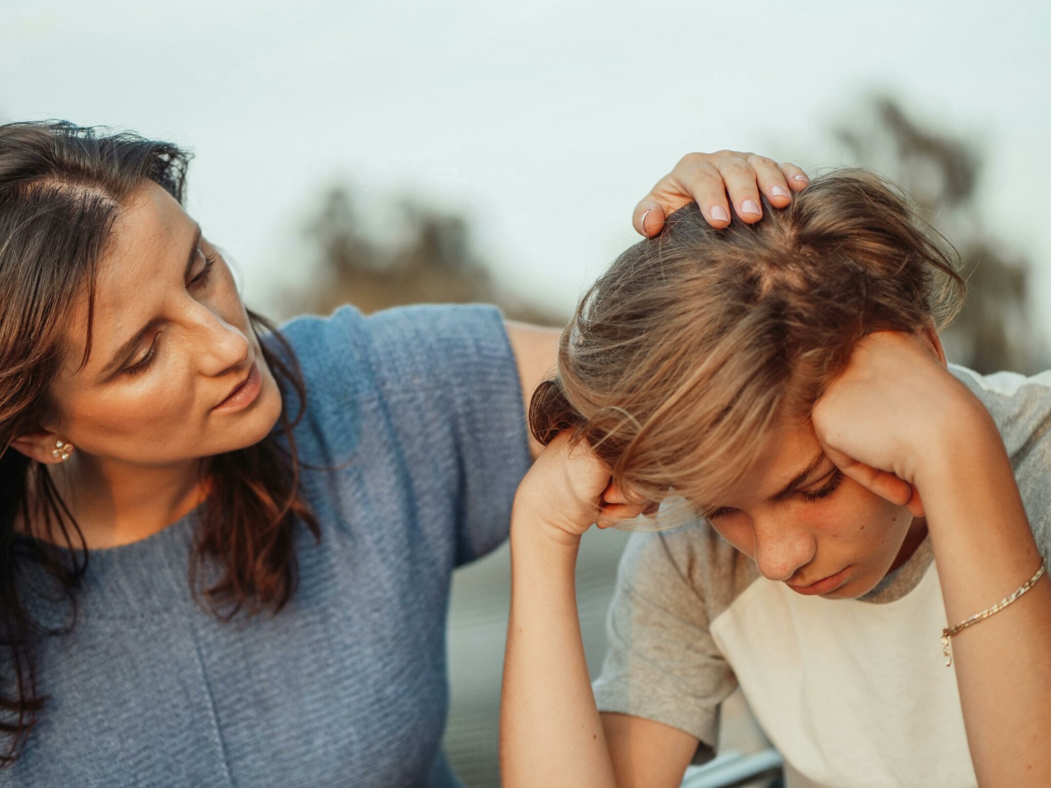 Kid with anxiety being comforted by their parent.