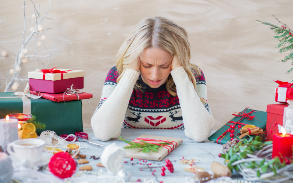 Blonde femalep surrounded by presents and christmas crafts looking distressed